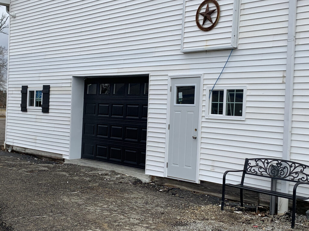 Black traditional garage door with windows.