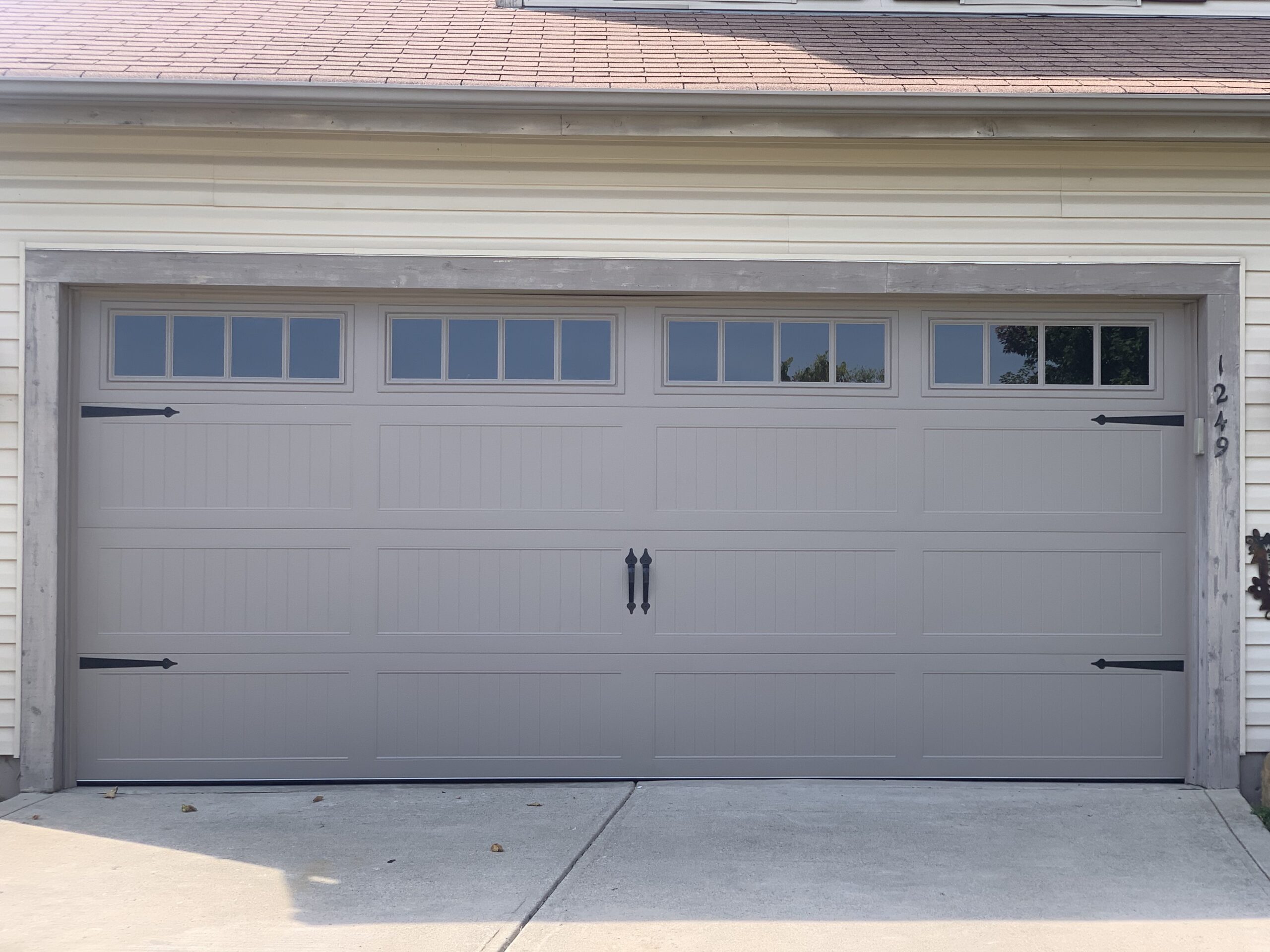 grey traditional garage door with black handles and hinges