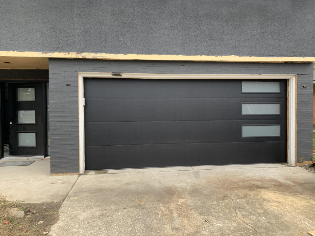 Black modern flushed panel garage doors with windows.